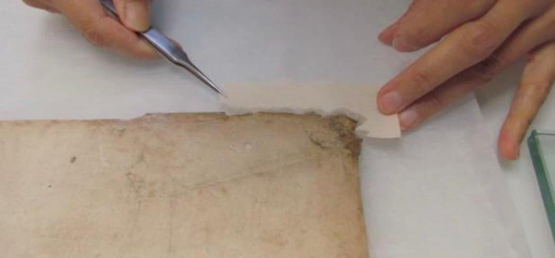 Mending a torn paper document with Japanese tissue and starch paste