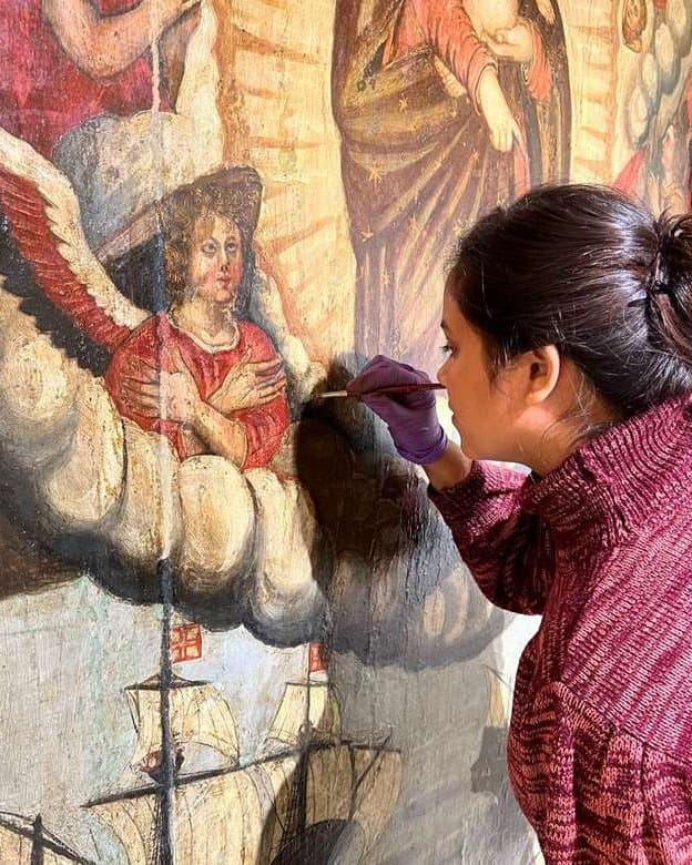 Smriti Rajput inpainting a colonial devotional oil painting in the conservation studio